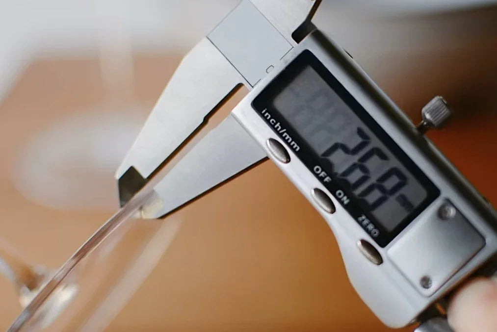 Digitale Schieblehre misst dünnen Rand eines hochwertigen Weinglases, Küchenaccessoire