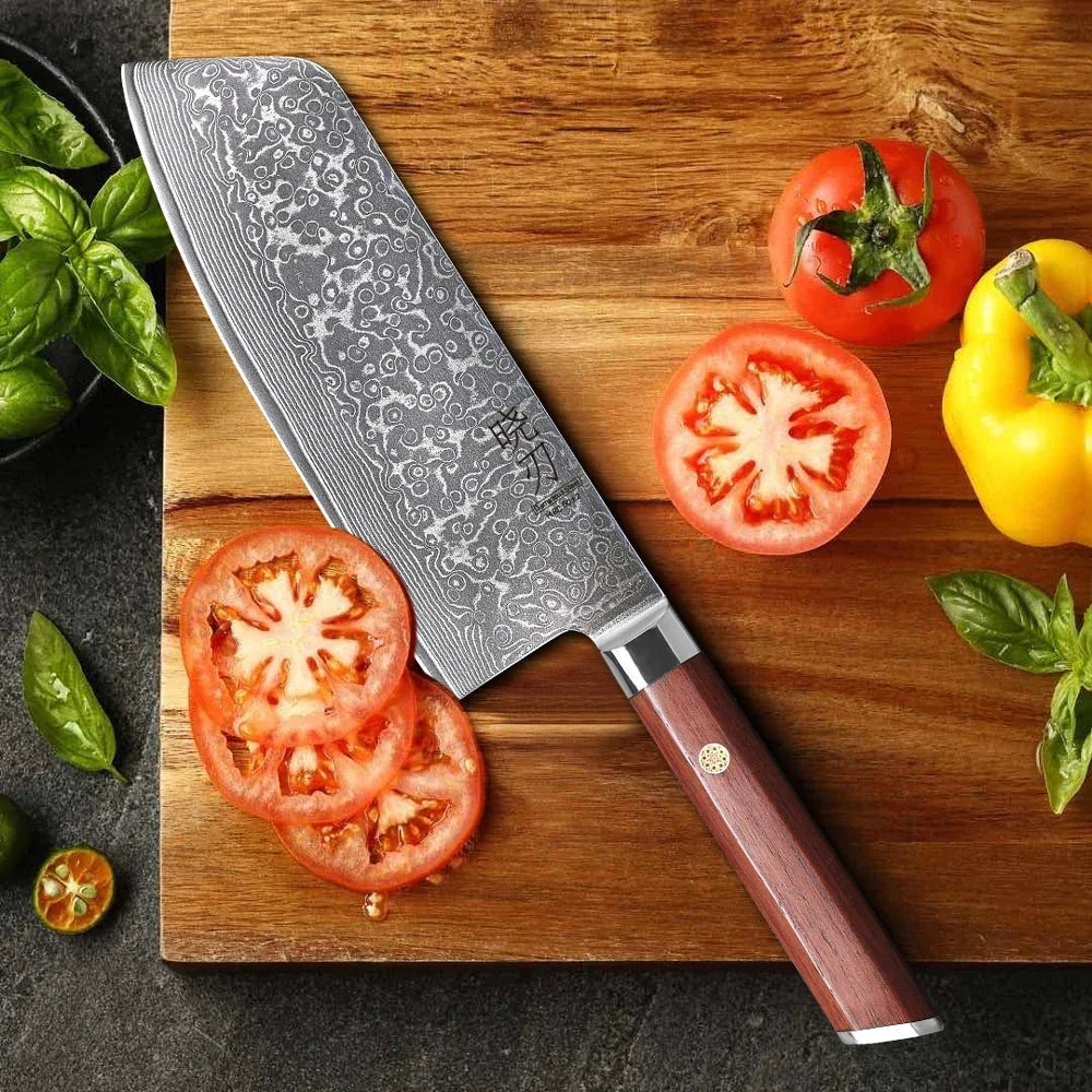 Damast Küchenmesser mit Holzgriff schneidet Tomaten auf Holzbrett, frisches Gemüse daneben