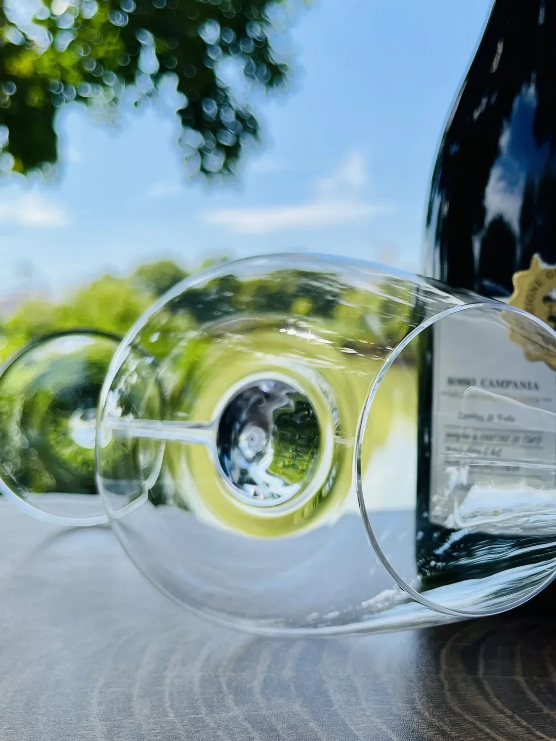 Edles Weinglas und Flasche auf Holztisch, exklusives Küchenzubehör, Stil und Genuss im Freien